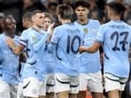 Manchester City's Belgian midfielder #11 Jeremy Doku (L) celebrates scoring the team's first goal during the English League Cup third round